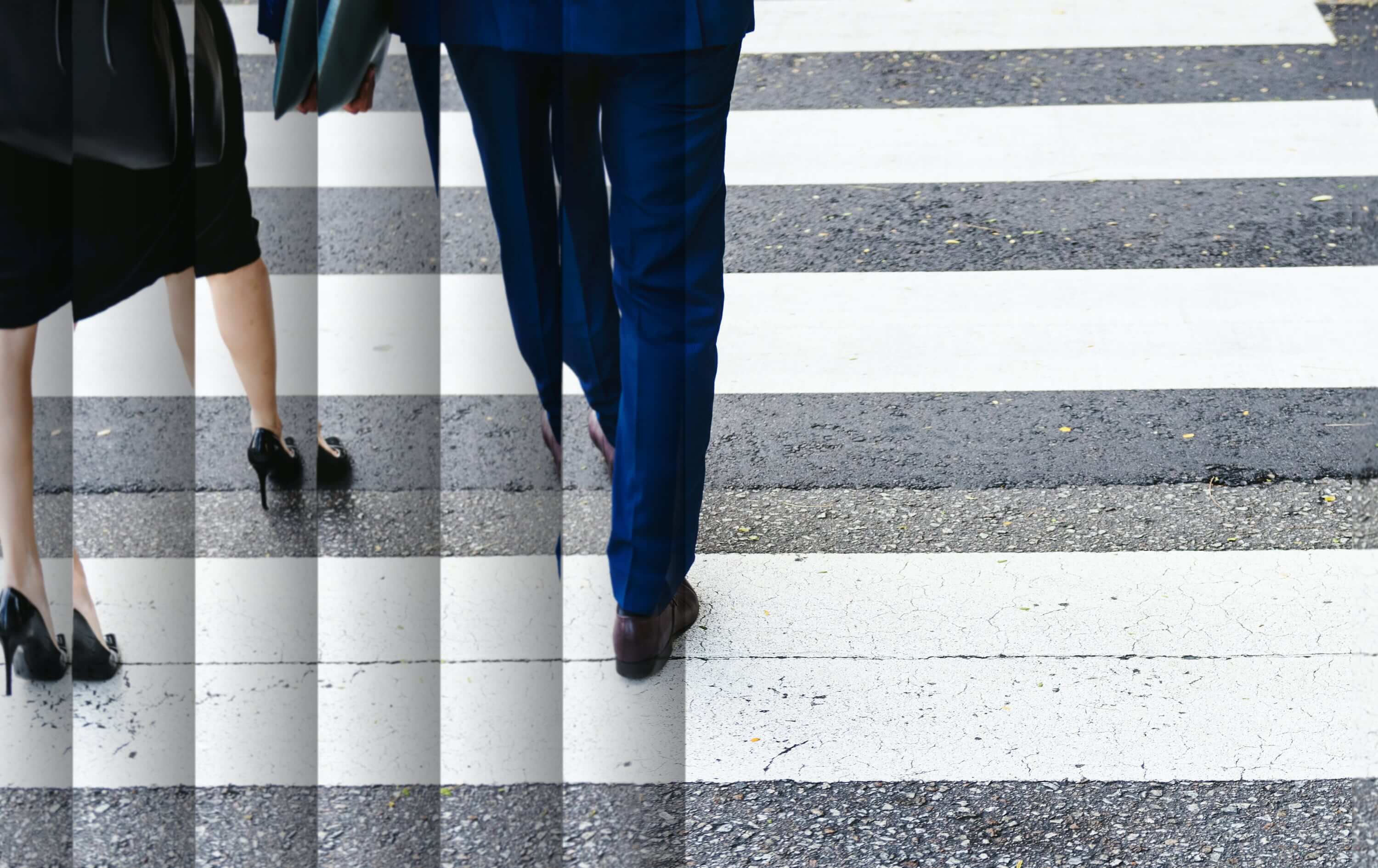 Two business people walking across crosswalk, image decorative only